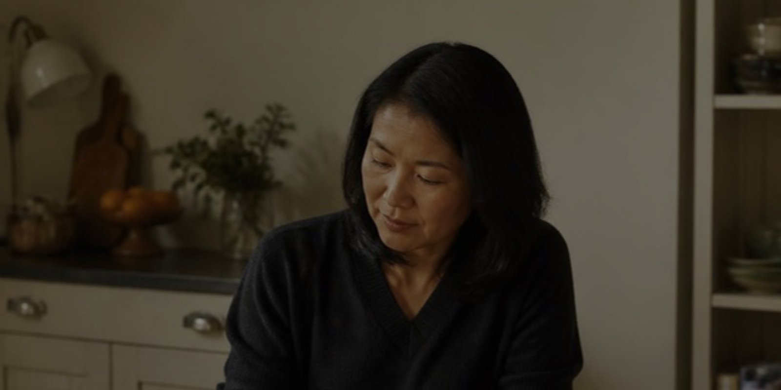 Woman sitting at her kitchen table, deep in thought